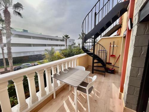 a balcony with a table and a spiral staircase at Adeje Paradise in Adeje