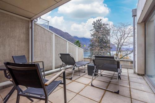 a balcony with chairs and a table with a view at Montreux Lake View Apartments and Spa - Swiss Hotel Apartments in Montreux