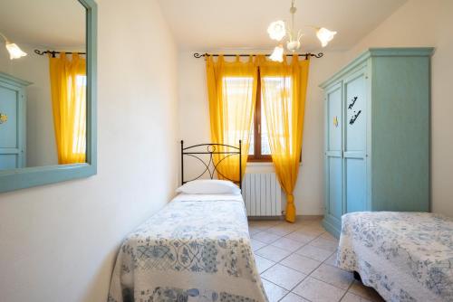 a bedroom with two beds and a mirror at Follonica Apartments - Pool & Relax in Follonica