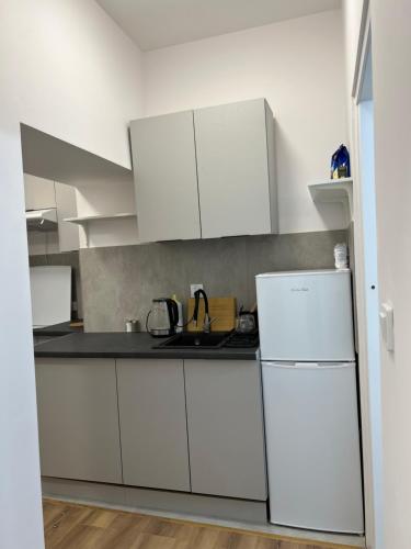 a kitchen with white cabinets and a white refrigerator at Nowe mieszkanie in Pabianice
