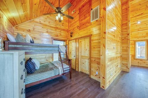 a log cabin bedroom with a bunk bed and a ceiling fan at WOW, that View! NEW Luxury Cabin - Hot Tub - Pool Access - Game Room in Sevierville