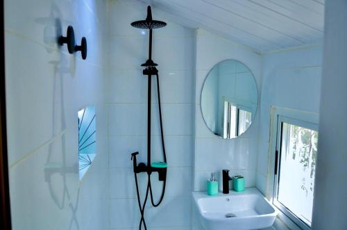 ein weißes Badezimmer mit Waschbecken und Spiegel in der Unterkunft La Villa Moringa, meublée et équipée in Saly Portudal