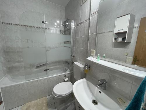 a bathroom with a toilet and a tub and a sink at BEIMS APARTMENT-Vollausstattung-Küche, kostenlos-WFI, Smart-TV in Magdeburg