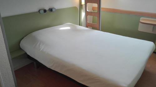 a large white bed in a room at ibis Budget Pau Est in Pau