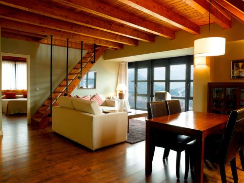 a living room with a staircase and a table and chairs at HG Cerler in Cerler