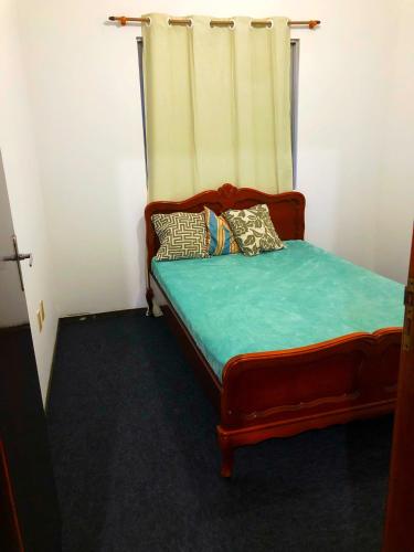 a bed in a room with a curtain at Quartos 50 metros do mar in Itapema