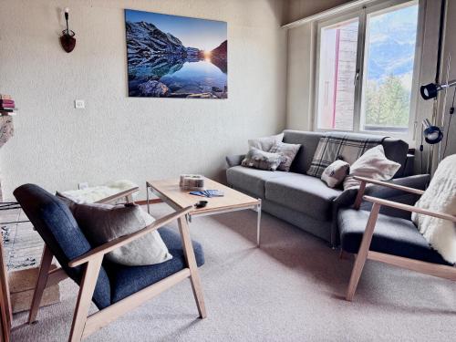 a living room with a couch and a table at Jungfraujoch, Chalet Ski In&Out, Wengen, Valley view in Wengen