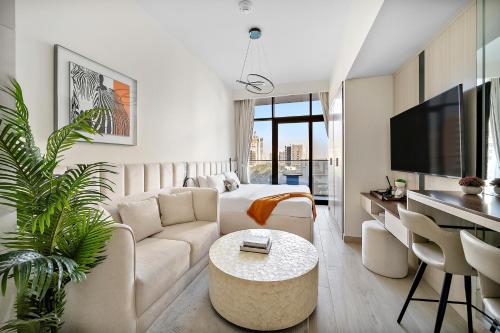a white living room with a couch and a table at Studio Azizi Riviera 35, Community View in Dubai