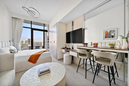 a hotel room with a bed and a desk and a kitchen at Studio Azizi Riviera 35, Community View in Dubai