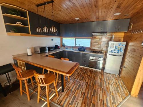 a kitchen with a table and some chairs in it at Casa con acceso directo a playa en condominio in Pichilemu