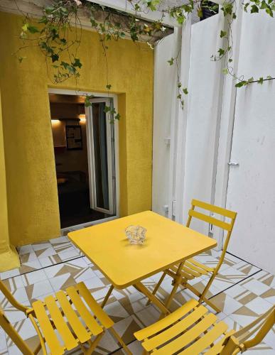 a yellow table and chairs on a patio at Hôtel La Nouvelle République & Hammam in Paris