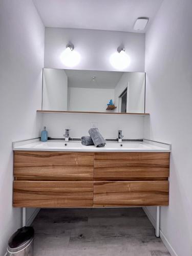 une salle de bain avec un lavabo et un grand miroir dans l'établissement MAISON DES OSIERS-JUSQU'A 6 PERSONNES-WIFi, à Pétosse
