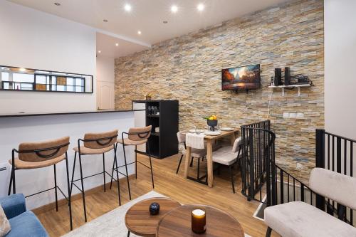 une cuisine et une salle à manger avec un mur en briques dans l'établissement charmant et chaleureux paris 17ème, à Paris
