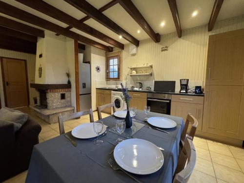 une table à manger avec un chiffon bleu et une cuisine dans l'établissement Le Chalet D'EsusTerra - 4pers - Rêve au Mans, à Aubigné-Racan