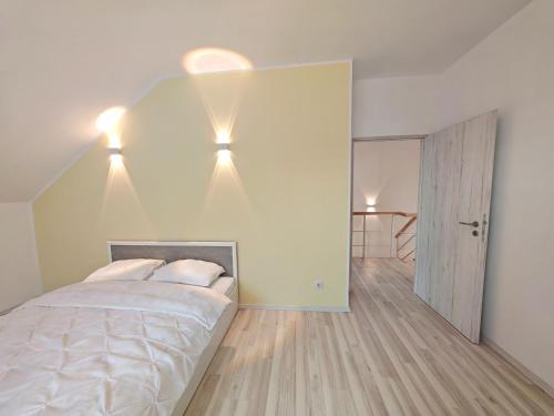 a bedroom with a bed and lights on the wall at Vila Novara V25 in Bordeiu