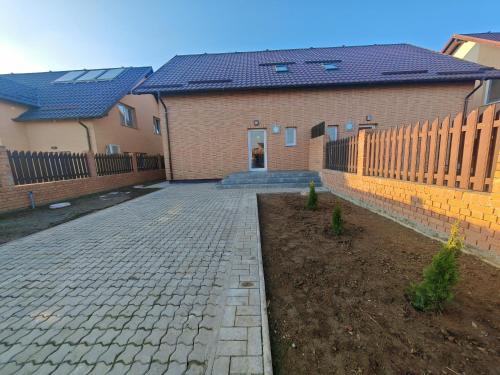 a brick house with a fence and a brick driveway at Vila Novara V25 in Bordeiu