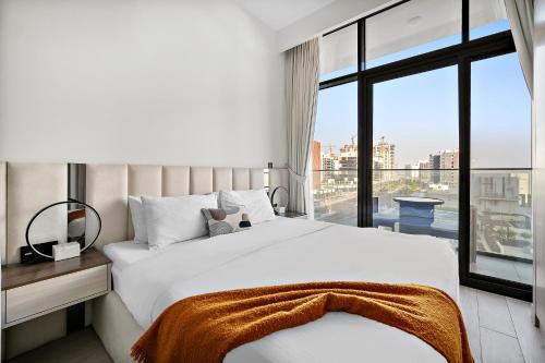 a bedroom with a white bed and a large window at Studio Azizi Riviera 35, Community View in Dubai