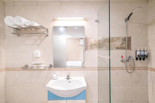 Bilik mandi di Dequan Xin Yue Hotel Coffee, fruits, snacks, a gym and a laundry room are provided for free in the lobby
