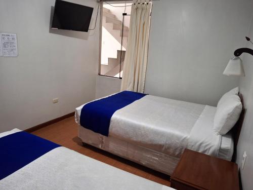 a hotel room with two beds and a window at Hotel Sideral AQP in Arequipa