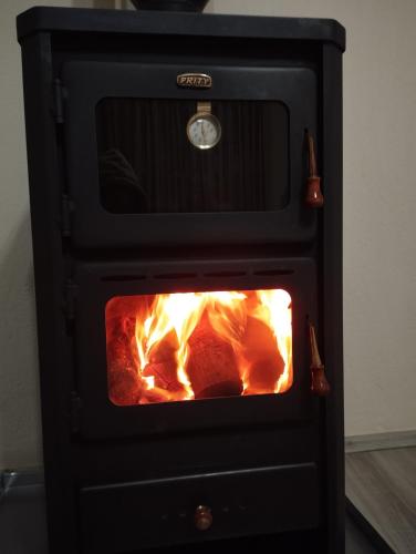 a stove with a fire inside of it at RONDO Guesthouse in Gjirokastër