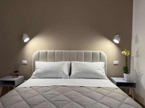 a bedroom with a white bed with two night stands at Riviera Smart Rooms in Fondi