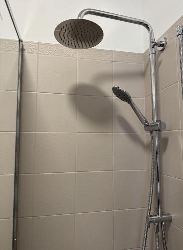 a shower with a shower head in a bathroom at Riviera Smart Rooms in Fondi