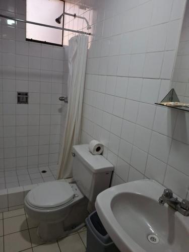 a white bathroom with a toilet and a sink at Hotel Sideral AQP in Arequipa