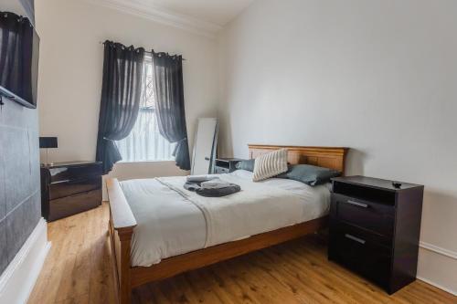 a bedroom with a bed with a dresser and a television at Hullidays City Centre Urban Apartment 2 in Hull