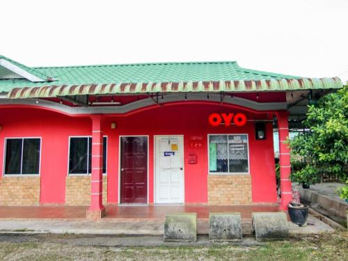 a red building with the number on it at OYO 89684 Mawaddah Inn Stay in Tangkak