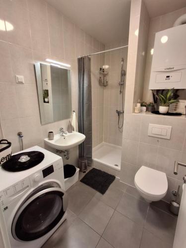 a bathroom with a toilet a sink and a washing machine at Apartman Tonka in Šibenik