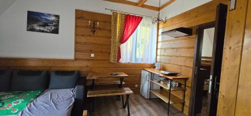 a bedroom with a bed and a desk and a window at Pokoje Gościnne U Ogórków in Witów