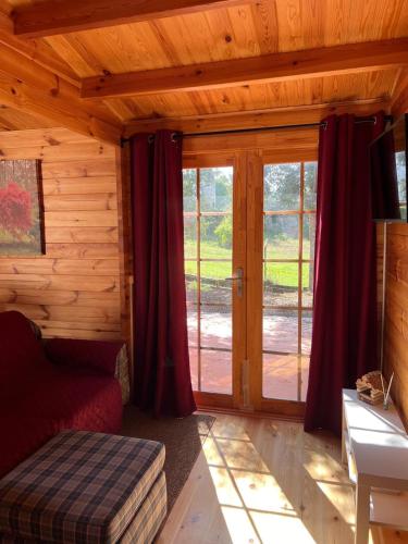 a bedroom with sliding glass doors in a log cabin at Quinta do Pinheiro in Ourém