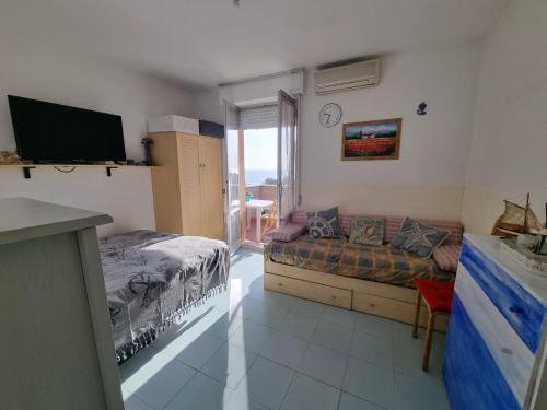 a bedroom with a bed and a couch and a television at Grazioso bilocale vicino al mare in Porto Recanati
