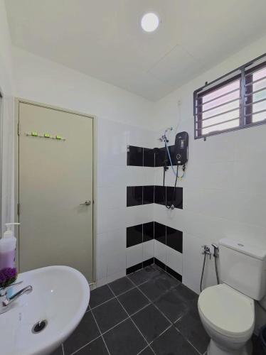 a bathroom with a white toilet and a sink at SD Home in Rawang in Batu Arang
