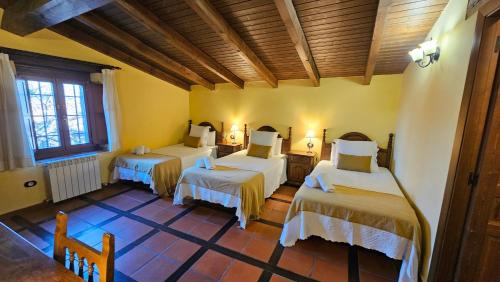 a bedroom with three beds in a room at La Clerecia de Ledesma in Ledesma