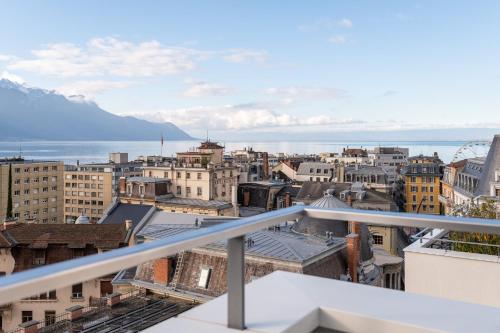 a view of a city from a balcony at Montreux Lake View Apartments and Spa - Swiss Hotel Apartments in Montreux
