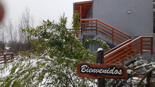 a sign in front of a building with snow on the ground at Posada La Pedrera in Villa Yacanto