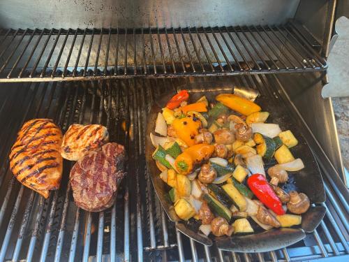 a grill with a plate of vegetables and a hamburger at Kaanapali's Royal Luxury Plantation Beach & Golf Retreat in Kaanapali