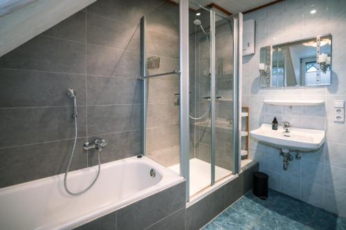 a bathroom with a shower and a tub and a sink at Moselträubchen in Enkirch