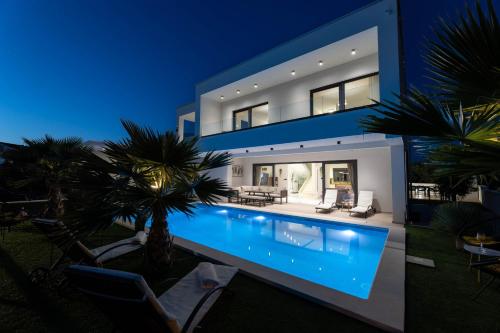 een groot huis met een zwembad in de nacht bij Villa Golden Shine in Primošten