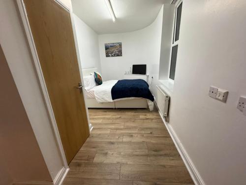 a small bedroom with a bed and a hallway at Sangha Hall in Leicester