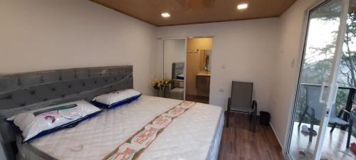a bedroom with a large bed and a large window at Casa campestre Los Nogales BC in Manaure Balcón del Cesar