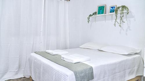 a white room with a bed with towels on it at Estrella de Mar in Pedernales