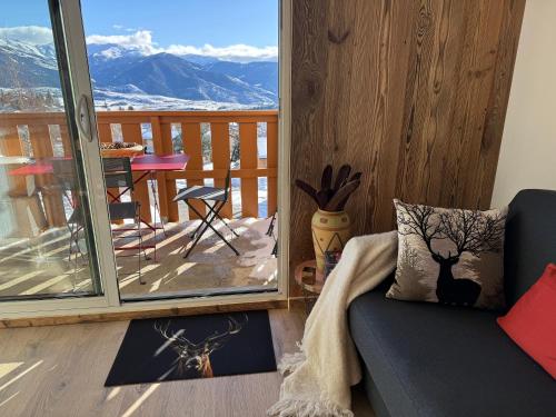 a living room with a couch and a balcony with a view at la terrasse du belvédère in Font-Romeu