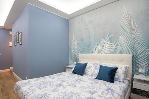 a bedroom with blue walls and a bed with blue pillows at Appia - Regina Viarum B&B in Rome