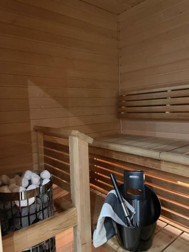 a sauna with a bucket and utensils in it at Spa Hotel RED in Tahkovuori