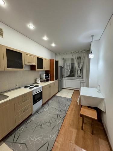 a kitchen with wooden cabinets and a table in it at Apartments Zhayau Musa 7b in Pavlodar