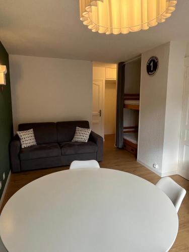 un salon avec une table blanche et un canapé dans l'établissement Mignon petit Studio 25m2 avec balcon et Parking face départ pistes !, à Demi-Quartier