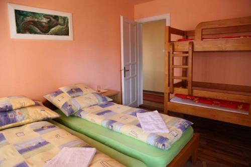 two beds in a room with two bunk beds at Zárug Vendégház in Lăzarea
