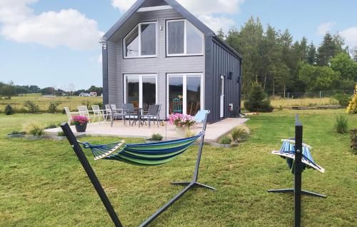 a hammock in the grass in front of a house at Awesome Home In Sianow With Sauna in Sianów